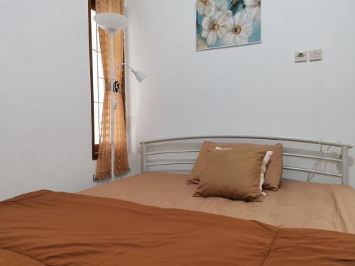 a bed with two pillows on it in a bedroom at Ambarukmo Green Hill / MA 8 in Yogyakarta