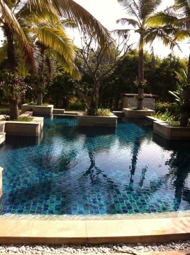 una piscina con azulejos azules en un complejo en Ban Na en So Tuk
