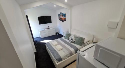 a small bedroom with a bed and a television at Esplanade Gateway in Port Noarlunga South