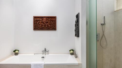 a bathroom with a sink and a picture on the wall at Lynnaya Urban River Resort in Siem Reap