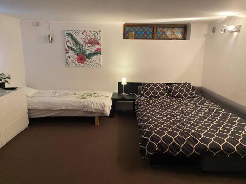 um quarto com uma cama e uma secretária com um candeeiro em Entire Basement Level in Eneby em Norrköping