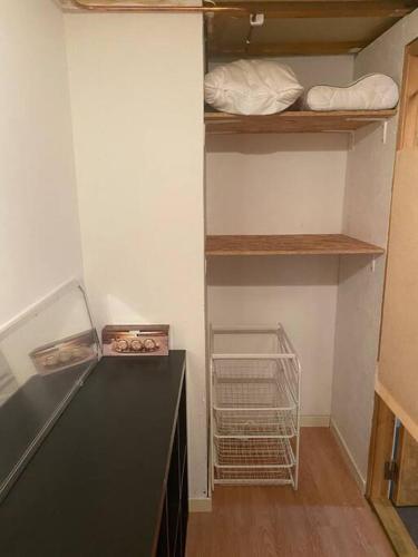 a room with a kitchen with a counter and shelves at Entire Basement Level in Eneby in Norrköping