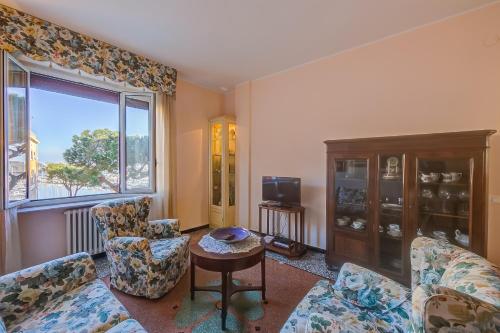 - un salon avec des chaises, une table et une fenêtre dans l'établissement Sunrise Apartment Seaview - Happy Rentals, à Imperia