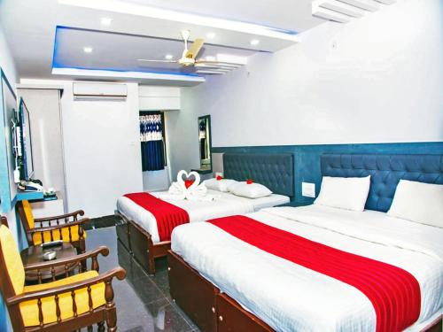a hotel room with two beds and a chair at Hotel Hill View in Madikeri