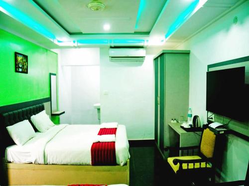 a bedroom with a bed and a desk and a television at Hotel Hill View in Madikeri
