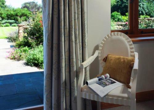 a white chair with a book and a window at Horsham-Gatwick 16 miles Luxury-near Leonardslee in Horsham