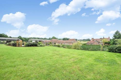 a large green field with houses in the background at Horsham-Gatwick 16 miles Luxury-near Leonardslee in Horsham