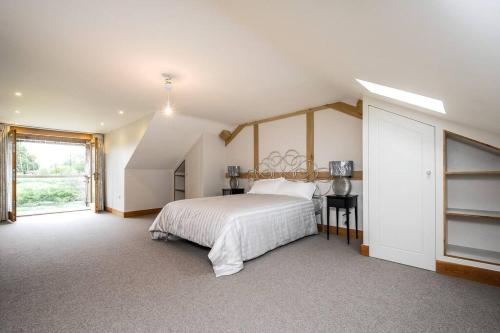 a white bedroom with a bed and a window at Horsham-Gatwick 16 miles Luxury-near Leonardslee in Horsham