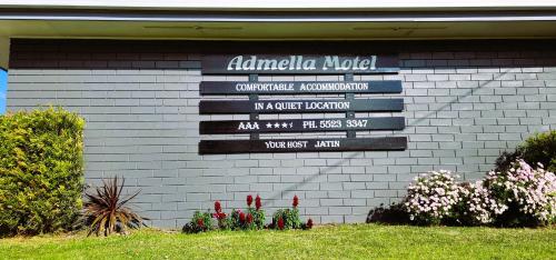 a sign on the side of a building with flowers at Admella Motel in Portland
