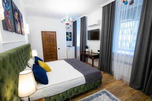 a bedroom with a bed with blue and yellow pillows at Metelitsa Hotel in Karagandy
