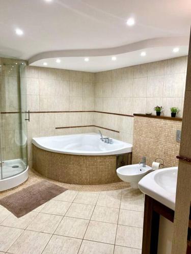 a bathroom with a tub and a toilet and a sink at Domek Mustang in Bytom