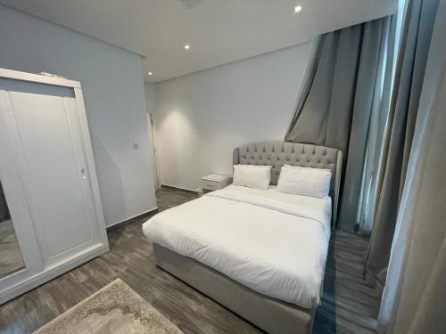 ein Schlafzimmer mit einem weißen Bett und einem Fenster in der Unterkunft Gulf grand hotelجلف جراند اوتيل in Kuwait