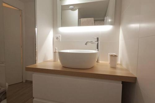La salle de bains est pourvue d'un lavabo blanc et d'un miroir. dans l'établissement Appartement à quelques pas de la mer et du centre, à Merlimont