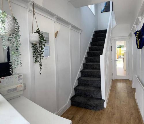 a staircase in a home with white walls and wood floors at Boss Fab4 Stay &Garden Pro Host in Liverpool