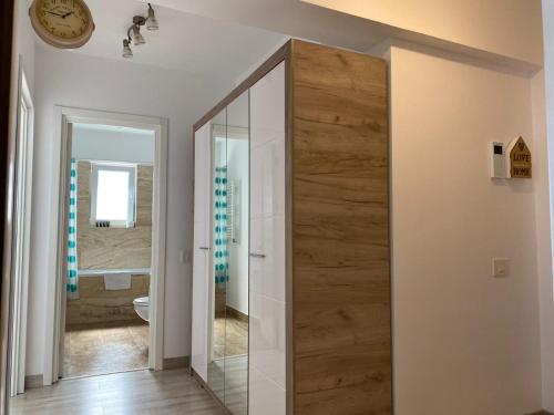 a pivot door in a bathroom with a mirror at Luxury Apartments Newton by GLAM in Iaşi