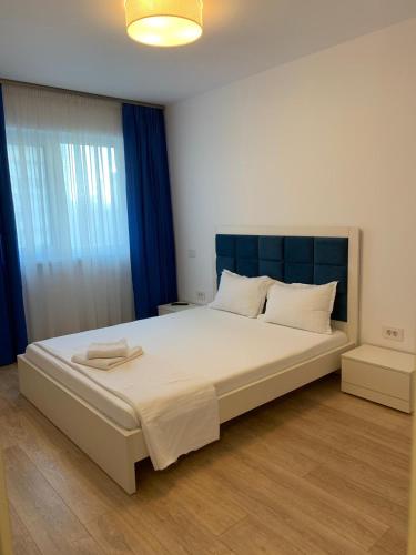 a bedroom with a large bed with a blue headboard at Luxury Apartments Newton by GLAM in Iaşi