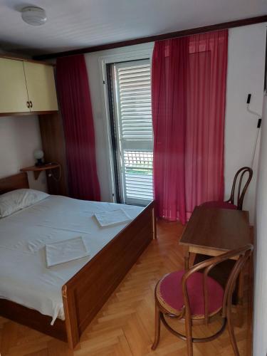sypialnia z łóżkiem, stołem i oknem w obiekcie Apartment Borik w mieście Zadar