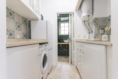cocina con nevera blanca, lavadora y secadora en Castelo Premium by Homing, en Lisboa