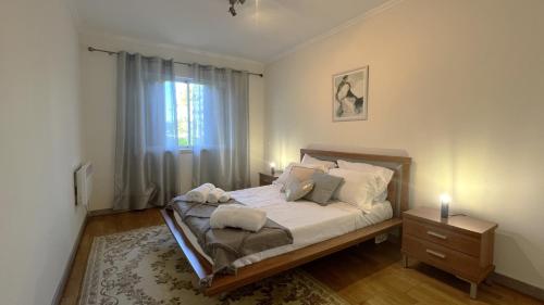 a bedroom with a bed with a dresser and a window at Golf and Beach Serenity in Aroeira