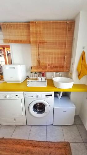 a bathroom with a washing machine and a sink at Casa Ane - Gäste Apartment in Renningen