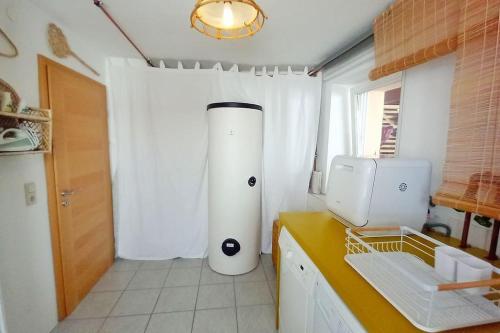 a kitchen with a white refrigerator and a window at Casa Ane - Gäste Apartment in Renningen