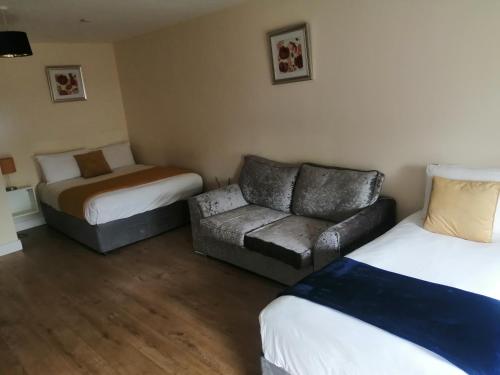 um quarto de hotel com um sofá e uma cama em Tara View Apartments em Garristown