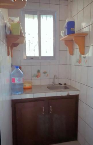 杜阿拉的住宿－Chambre meublee situee a Douala- Logbessou，厨房设有水槽和窗户。