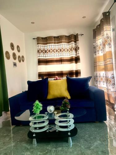 杜阿拉的住宿－Chambre meublee situee a Douala- Logbessou，客厅配有蓝色的沙发和桌子