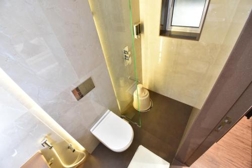 a small bathroom with a toilet and a window at Hotel Kalpana Palace, Mumbai in Mumbai