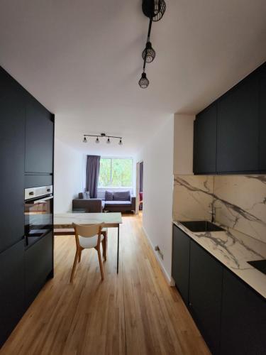 a kitchen with black cabinets and a table and a couch at Herstusio W11 in London