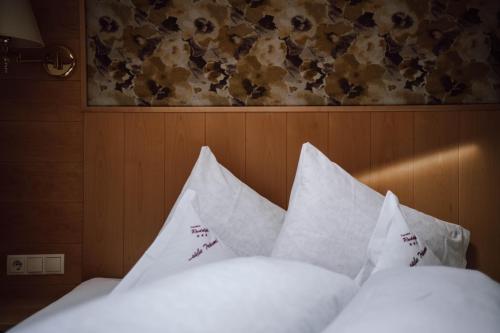a bed with white sheets and pillows at Pension Rudolph in Gaschurn