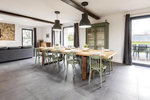 une salle à manger avec une grande table et des chaises en bois dans l'établissement Grand Bretonnerie, à La Haie-Fouassière