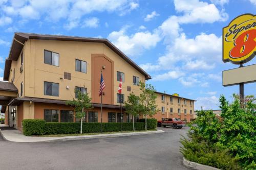 a view of a hotel with an american flag and a sign at Super 8 by Wyndham Butte MT in Butte