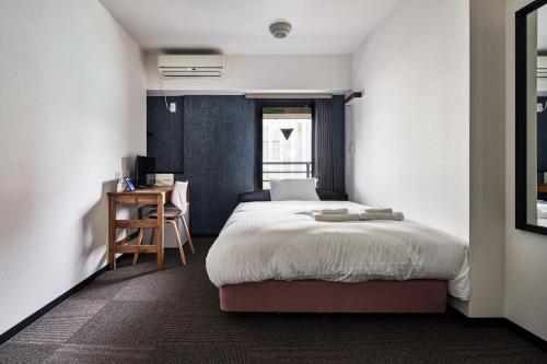 a bedroom with a bed and a desk in it at Hotel STARRIZE in Fukuoka