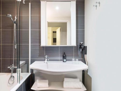 a bathroom with a sink and a shower at Aparthotel Adagio Paris Opéra in Paris