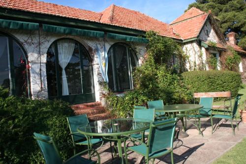 a patio with tables and chairs in front of a building at Posada los Cedros in La Cumbre