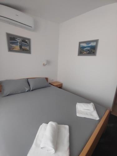 a bedroom with a bed with two pictures on the wall at APARTMANI VALJEVO in Valjevo