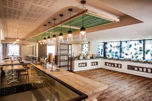 a restaurant with tables and chairs and windows at StayEasy Cape Town City Bowl in Cape Town