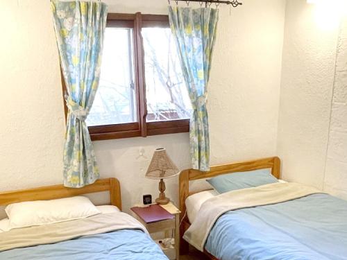 two beds in a room with a window at Gallery HARA & GUESTHOUSE - Vacation STAY 68643v in Hara