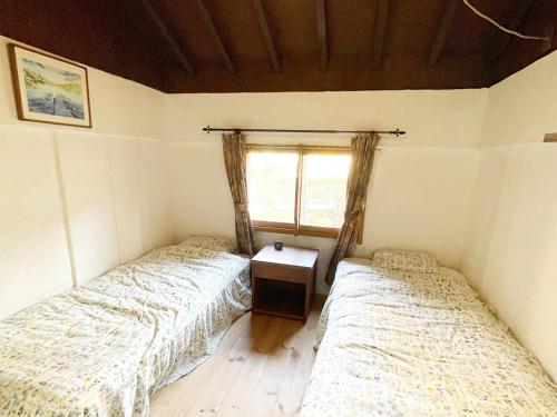 2 camas en una habitación pequeña con ventana en Gallery HARA & GUESTHOUSE - Vacation STAY 95372v en Hara