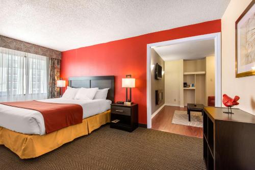 a hotel room with a bed with a red wall at Quality Inn & Suites in Mississauga