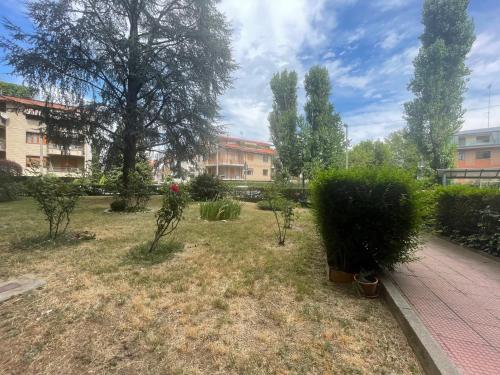 a garden with trees and bushes and a building at Casa Isabel in Cuneo