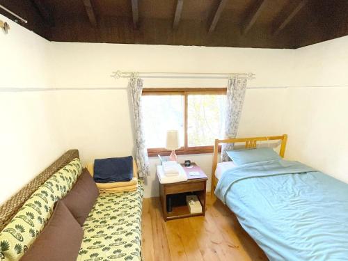 een slaapkamer met een bed, een bank en een raam bij Gallery HARA & GUESTHOUSE - Vacation STAY 90971v in Hara