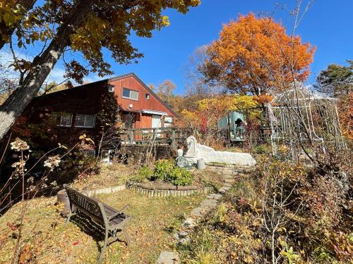 un giardino con panchina di fronte a una casa di Gallery HARA & GUESTHOUSE - Vacation STAY 90971v a Hara