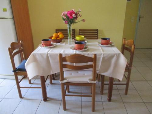 a table with a vase of flowers and fruit on it at Anna's Sweet Home Akrata in Paralía Akrátas