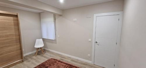 Habitación blanca con armario y puerta en Apartamento La Estación - Para 6, en Avilés