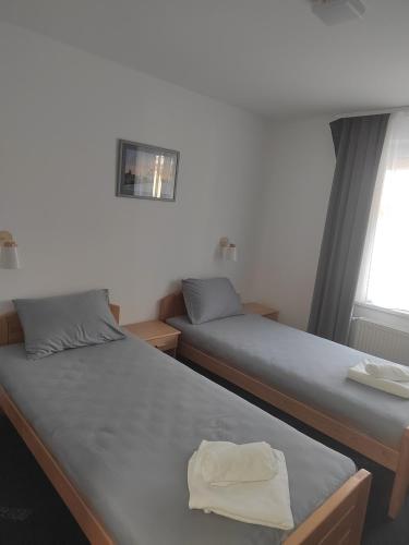 two twin beds in a room with a window at APARTMANI VALJEVO in Valjevo