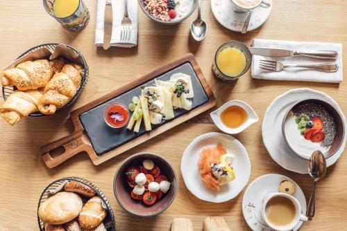 einen Tisch mit Teller mit Speisen und Tassen Kaffee in der Unterkunft Bed & Breakfast Hotel Märzenklamm in Stumm