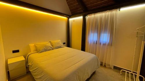 a bedroom with a white bed and a window at Casa del lago in Sanlúcar de Barrameda