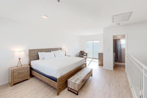 a white bedroom with a bed and a bench in it at Green Pineapple in Marathon